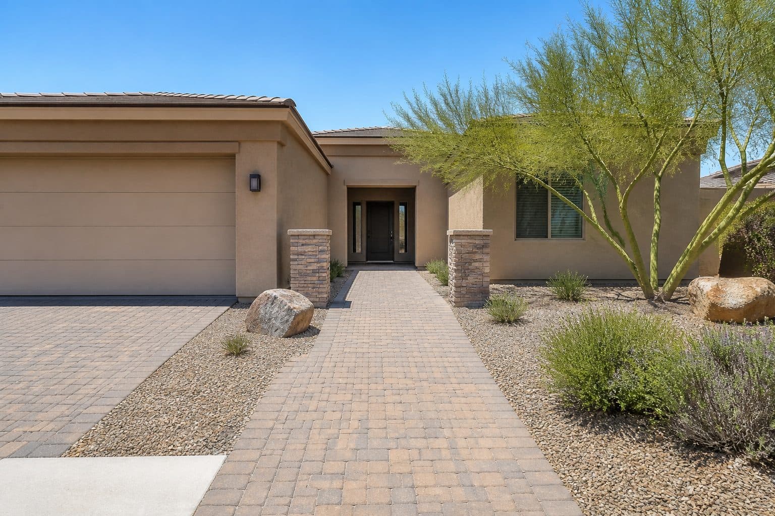 Single-level desert home with a wide, paved route from driveway to a low-threshold front door.
